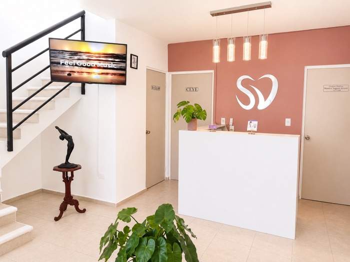 Vista del consultorio con la televisión y las escaleras de acceso